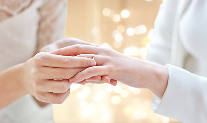 Image showing close up of lesbian couple hands with wedding ring