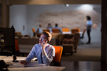 Image showing man using mobile phone in dark office