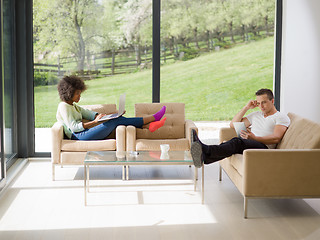 Image showing multiethnic couple relaxing at  home with laptop computers