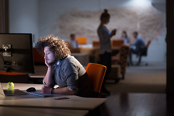 Image showing man working on computer in dark office