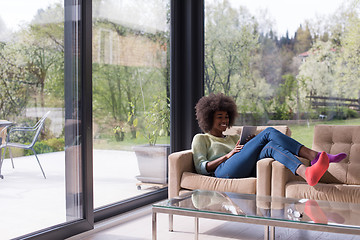 Image showing young african american woman at home using digital tablet