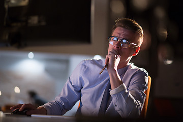 Image showing man working on computer in dark office