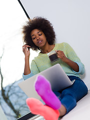 Image showing black woman in the living room on the floor