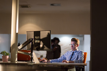 Image showing man working on computer in dark office