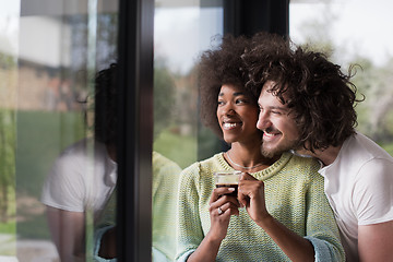 Image showing happy multiethnic couple relaxing at modern home indoors