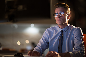 Image showing man working on computer in dark office