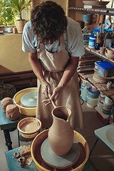 Image showing Creating a jar or vase of white clay close-up. Master crock.