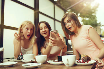 Image showing Two girl friends spend time together drinking coffee in the cafe, having breakfast and dessert.