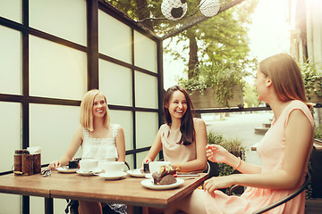 Image showing Two girl friends spend time together drinking coffee in the cafe, having breakfast and dessert.