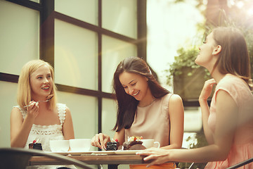 Image showing Two girl friends spend time together drinking coffee in the cafe, having breakfast and dessert.