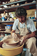 Image showing Creating a jar or vase of white clay close-up. Master crock.