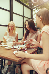 Image showing Two girl friends spend time together drinking coffee in the cafe, having breakfast and dessert.