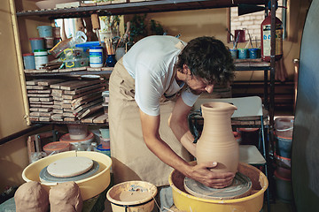 Image showing Creating a jar or vase of white clay close-up. Master crock.