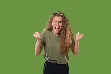 Image showing The young emotional angry woman screaming on green studio background