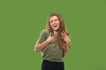 Image showing The happy woman standing and smiling against green background.