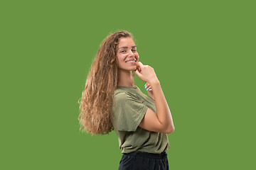 Image showing The happy woman standing and smiling against green background.