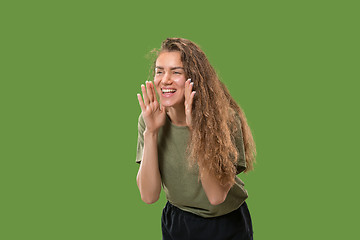 Image showing Isolated on green young casual woman shouting at studio