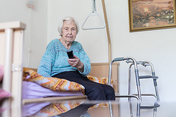 Image showing Elderly 96 years old woman operating TV or DVD with remote control