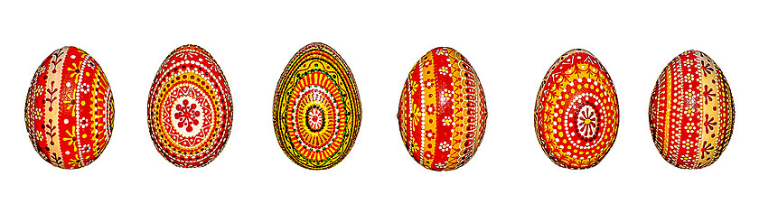 Image showing Wooden Easter eggs, painted in patterns by hand with acrylic paints, isolated on a white background.