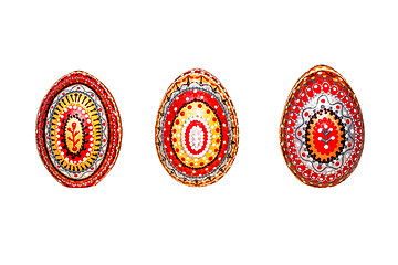 Image showing Wooden Easter eggs, painted in patterns by hand with acrylic paints, isolated on a white background.