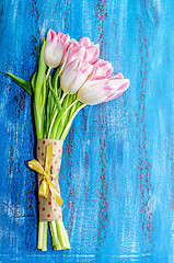 Image showing Bouquet of pink tulips on a blue wooden background, space for th