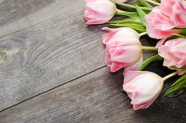 Image showing Bouquet of pink tulips on the background of old wooden boards with a place for the inscription, toned