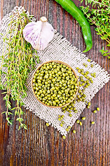 Image showing Mung beans in wooden bowl with thyme on dark board top