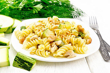 Image showing Fusilli with chicken and zucchini in plate on light wooden board