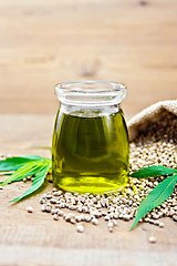 Image showing Oil hemp in jar with sheet on old board