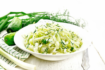 Image showing Salad of cabbage with cucumber in plate on light board