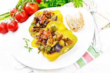 Image showing Pepper stuffed with vegetables in plate on white wooden board