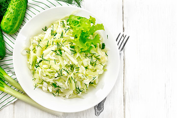 Image showing Salad of cabbage with cucumber in plate on board top