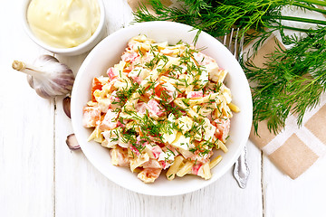 Image showing Salad of surimi and eggs with mayonnaise on wooden board top