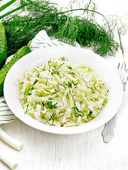 Image showing Salad of cabbage and cucumber in plate on board