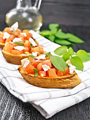 Image showing Bruschetta with tomato and feta on wooden board
