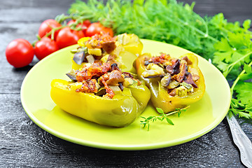 Image showing Pepper stuffed with vegetables in green plate on black board