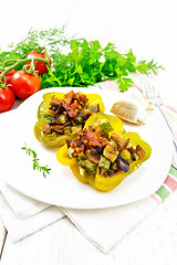 Image showing Pepper stuffed with vegetables in plate on light wooden board