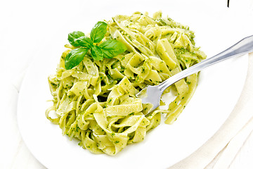 Image showing Pasta with pesto sauce in plate on board