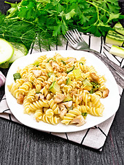 Image showing Fusilli with chicken and zucchini in plate on dark board