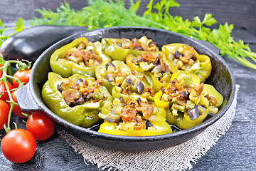 Image showing Pepper stuffed with vegetables in pan on wooden board