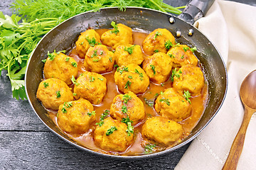 Image showing Meatballs in pan with greens on black board