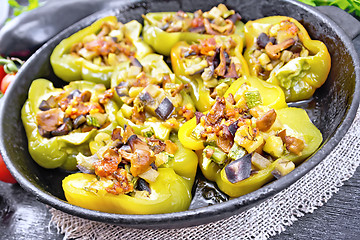 Image showing Pepper stuffed with vegetables in pan on black wooden board