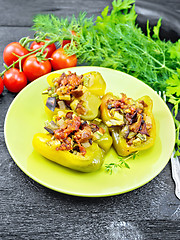 Image showing Pepper stuffed with vegetables in green plate on wooden board