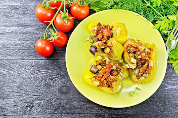 Image showing Pepper stuffed with vegetables in green plate on board top