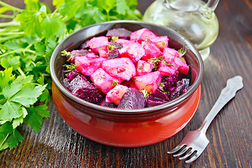 Image showing Salad of beets and potatoes in bowl on dark board