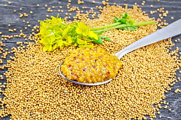 Image showing Sauce mustard Dijon in spoon with flower on black board