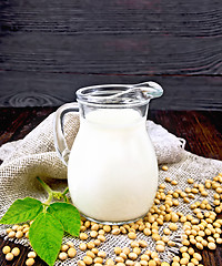 Image showing Milk soy in jug with soybeans and leaf on dark board