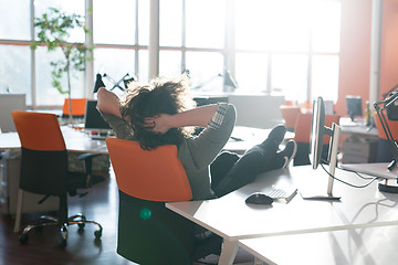 Image showing businessman sitting with legs on desk