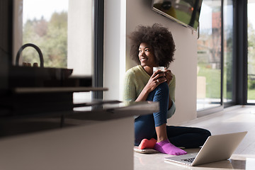 Image showing black woman in the living room on the floor