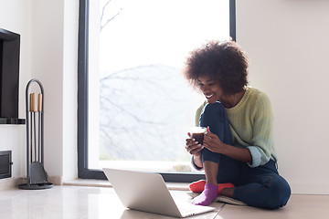 Image showing black woman in the living room on the floor